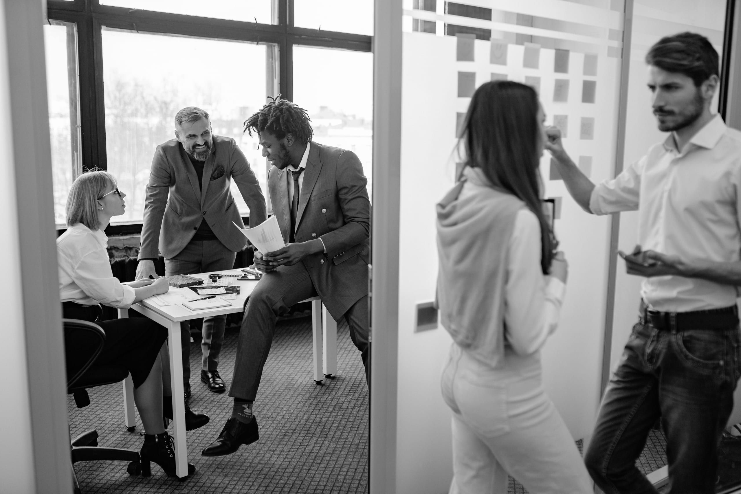 An agency team discussing a project in a glass-walled office